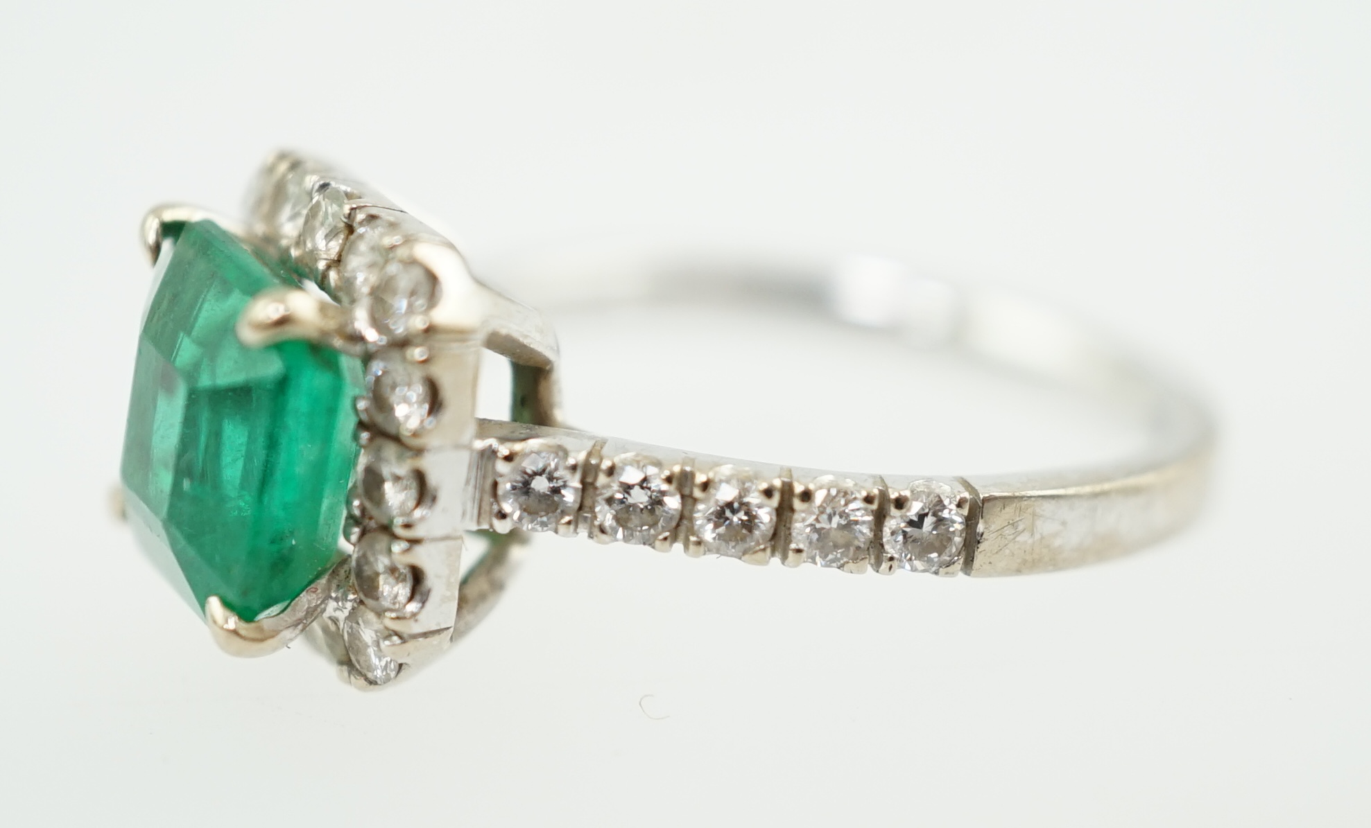 A modern 18k white gold, emerald and diamond set square cluster ring